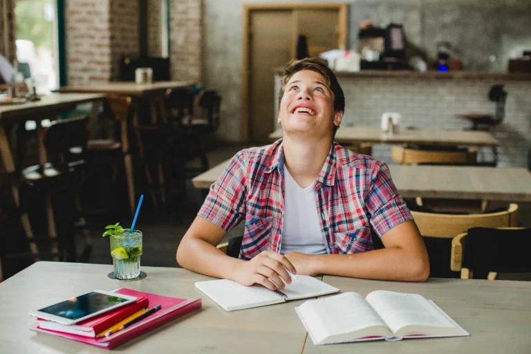 Chico sonriendo mientras estudia